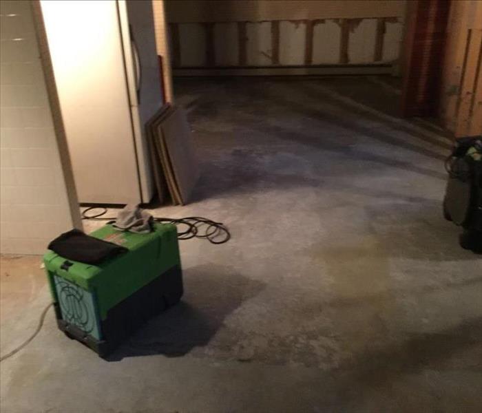 dried basement floor with the green SERVPRO air-mover at work