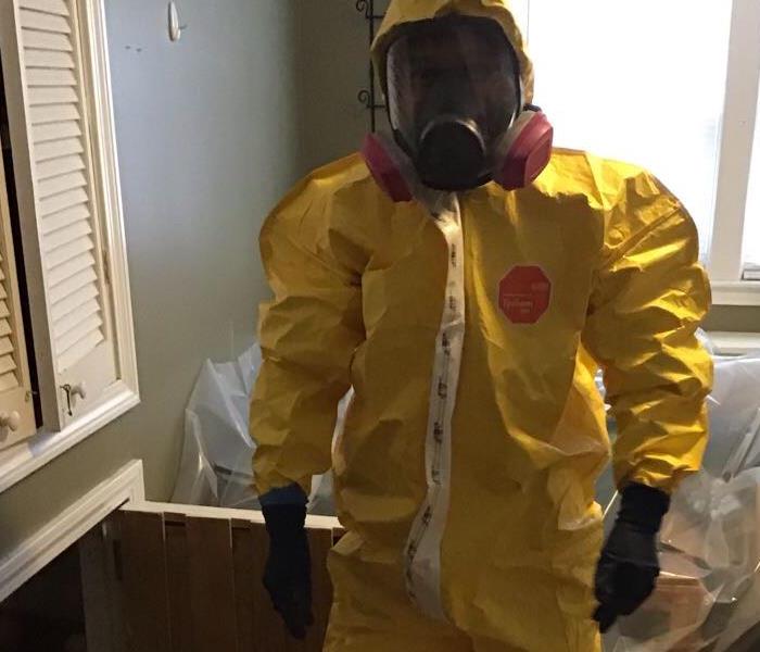 Our crew member wearing proper PPE during a mold remediation job: gloves, respirator, boot covers, full body suit. 